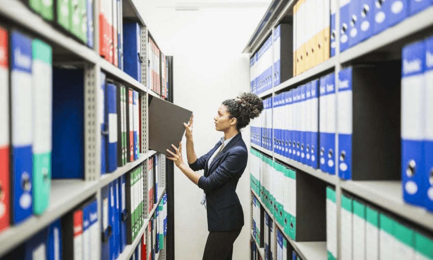 Secretary working in paper archive 
