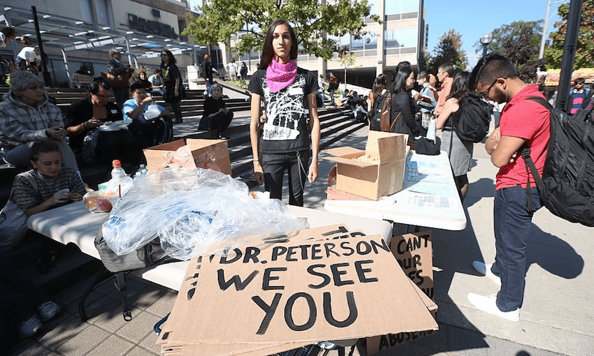 Cassandra Williams, a University of Toronto student union member, poses in front of a sign at the Jordan Peterson protest/rally (Vince Talotta/Toronto Star via Getty Images) 
