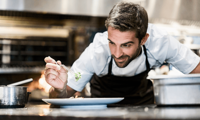 Concentrated chef garnishing food in a restaurant. 
