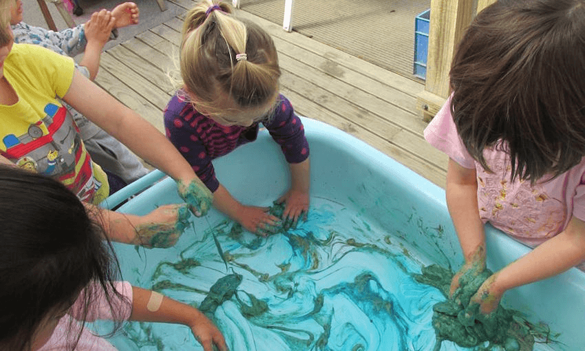 Children play with paint at the Karori Creche. (Photo supplied) 
