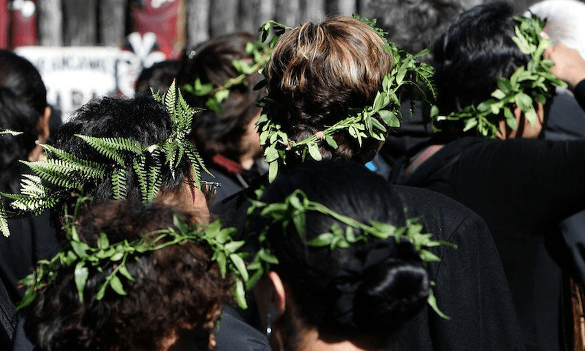 A group of Māori women wearing pare kawakawa, wreaths of kawakawa leaves on their heads as a sign of mourning.