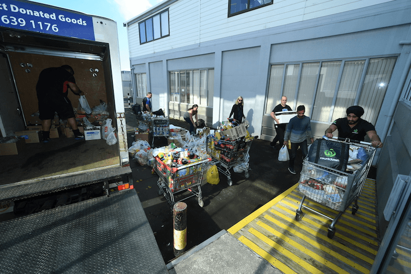 a truck surrounded by people with tables made of food