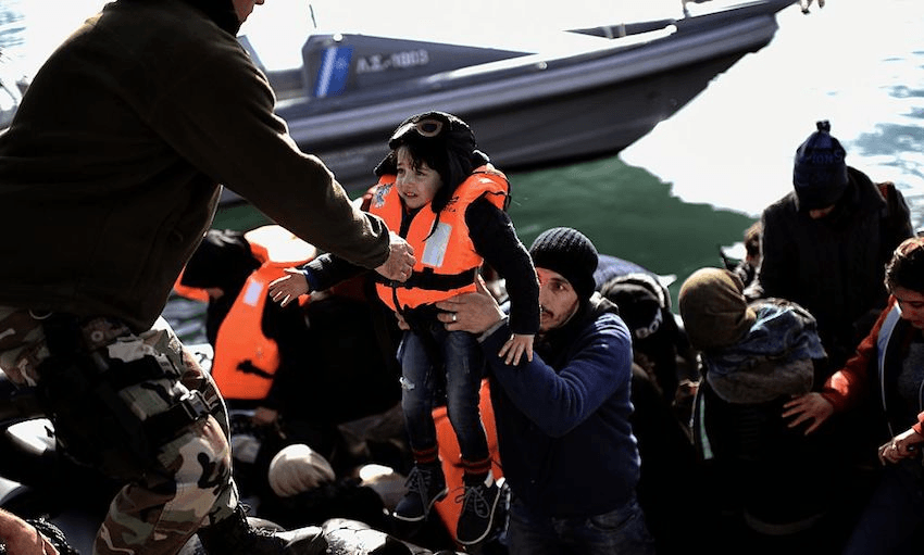A Greek coastguard helps a refugee child to disembark, at the port of Mytilene, on the Greek island of Lesbos after crossing the Aegean sea from Turkey, on February 18, 2016. 
(Photo: ARIS MESSINIS/AFP/Getty Images) 
