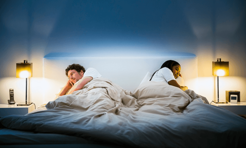 Couple ignoring each other on bed