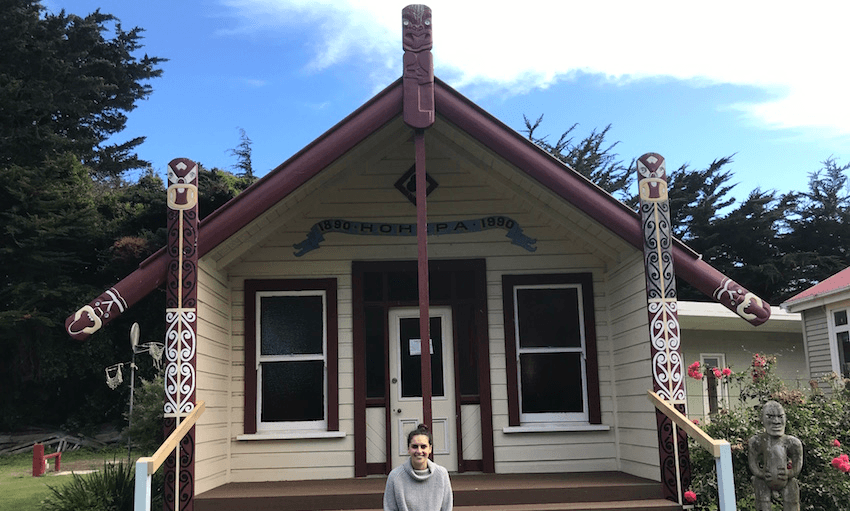 Meriana Johnsen sitting outside Mangamaunu marae in Kaikōura.  
