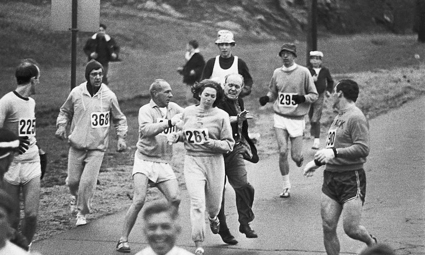 Trainer Jock Semple, in street clothes, enters the field of runners (left) to try to pull Kathrine Switzer (261) out of the race. (Photo: bettmann via Getty Images) 
