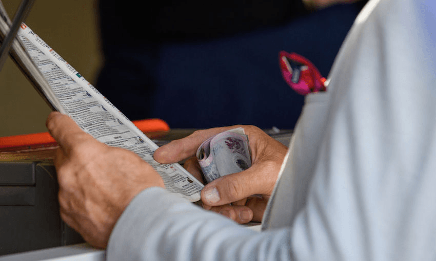 A racegoer places a bet during New Zealand Trotting Cup Day at Addington Raceway on November 13, 2018 in Christchurch, New Zealand. (Photo by Kai Schwoerer/Getty Images)