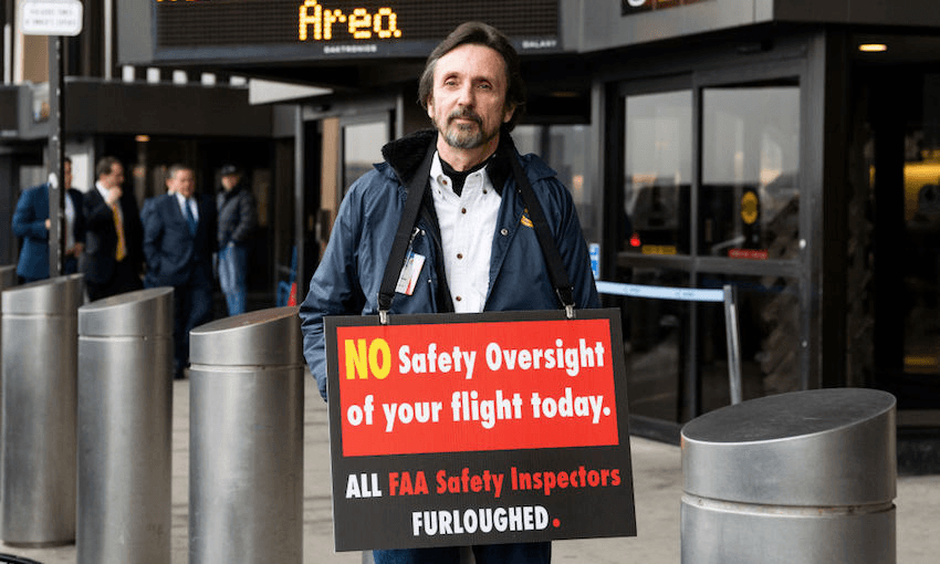A protestor outside Terminal B at Newark Liberty International Airport with a placard telling people that FAA Safety Inspectors have been furloughed in Newark, New Jersey, due to the government shutdown, January 8, 2019. (Photo by Michael Brochstein/SOPA Images/LightRocket via Getty Images) 

