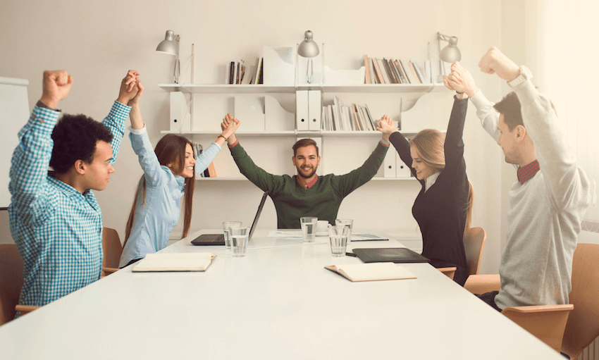 Group of young business people holding hands and celebrate their success.