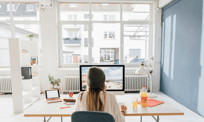 Back view of freelancer working at desk in a loft