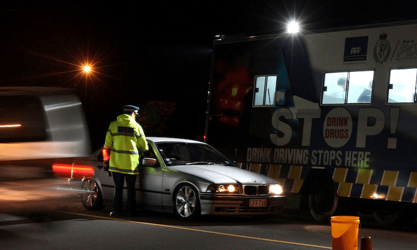 A police officer stops a motorist at a drink driving check point in Auckland. Photo: Getty Images 
