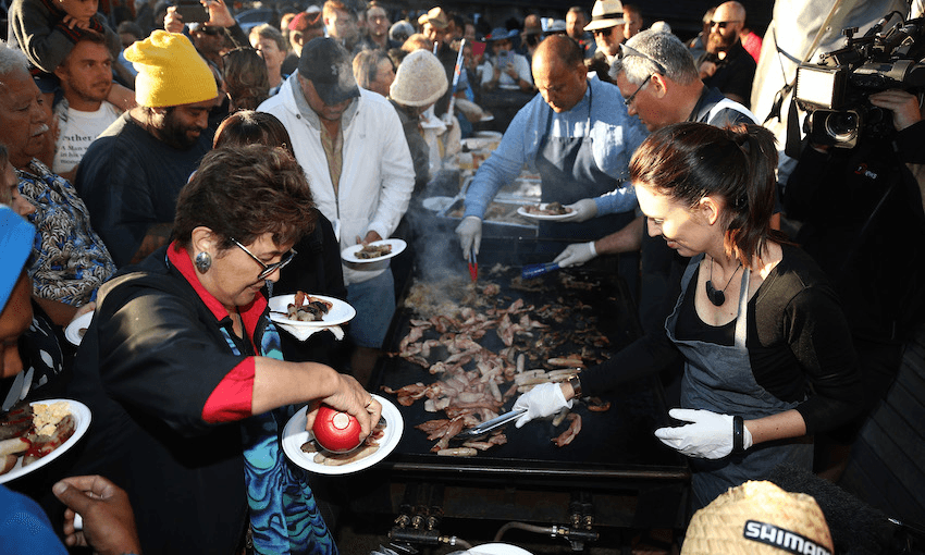 The PM and co get in on breakfast duty on the barbie after last year’s dawn service at Waitangi (Photo: Getty Images) 
