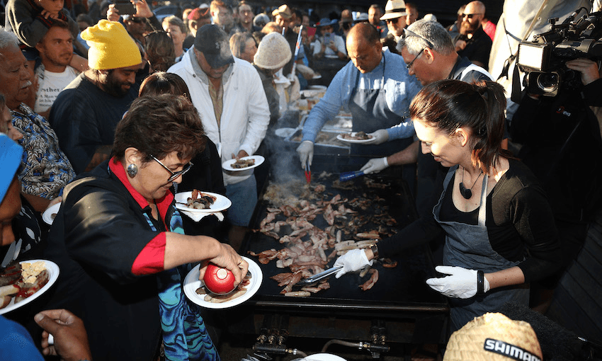 The PM and co get in on breakfast duty on the barbie after last year’s dawn service at Waitangi (Photo: Getty Images)