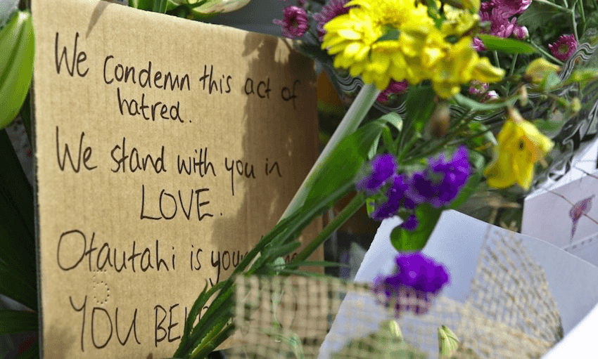 People lay flowers and notes to pay tribute close to the Al Noor Mosque shooting area, in Christchurch. Photo by Peter Adones/Anadolu Agency/Getty Images 
