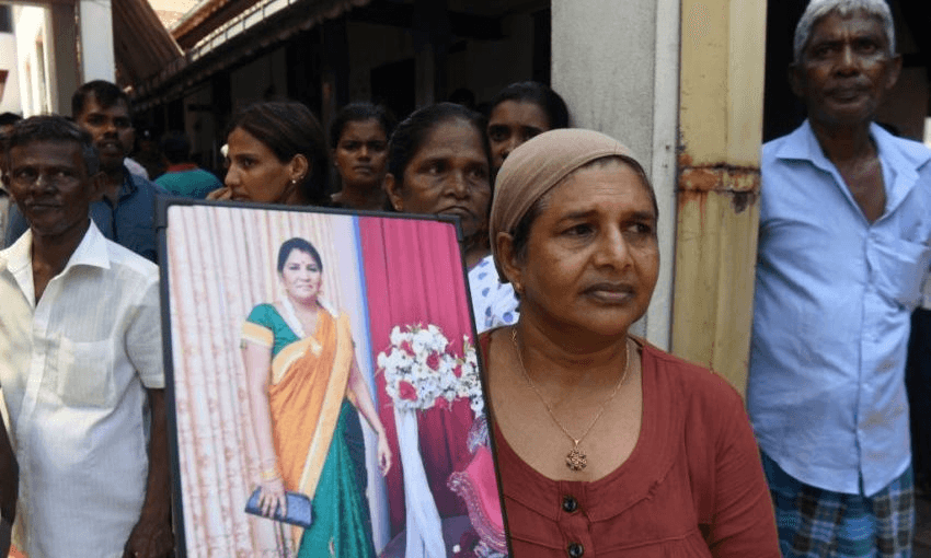 A Sri Lankan woman holds a photograph of a lost loved one in Colombo on Monday. Photo: LAKRUWAN WANNIARACHCHI/AFP/Getty Images) 
