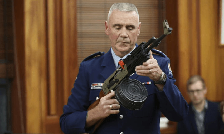 A police officer demonstrates illegal gun modifications. (Photo: RNZ / Ana Tovey) 
