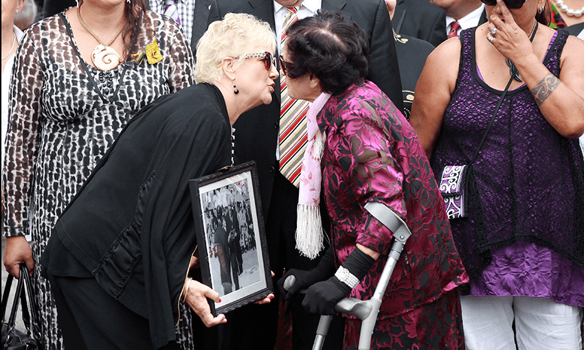 Labour MP Annette King (L), carrying a 40-year-old photo of former Prime Minister Norman Kirk at Waitangi, and Titewhai Harawira (R) exchange a kiss as they arrive at the Te Tii Marae on February 5, 2014 in Paihia, New Zealand. Photo by Jason Oxenham/Getty Images 
