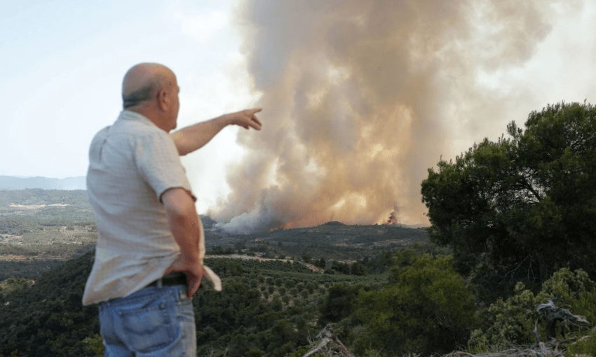 A man observes the wildfires currently sweeping through Catalonia, in Spain (Getty Images)