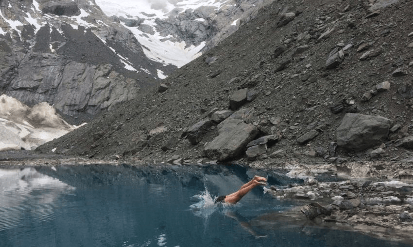 Nick Atkinson takes a plunge into a nameless Alpine lake. Photo: Finn Scholes 
