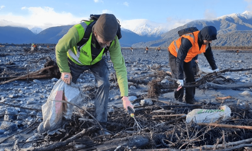 Volunteers bending their backs to pick up rubbish along the banks of the Fox River, in the West Coast (Image: Radio NZ) 
