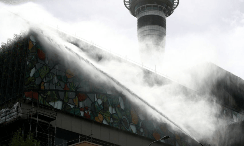 Firefghters continue to douse the roof of the SkyCity Convention Centre. Photo by Phil Walter/ Getty Images 

