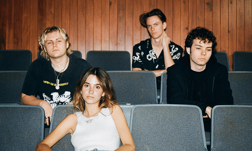 A press photo of the band Daffodils, shot in a wood-panelled movie theatre