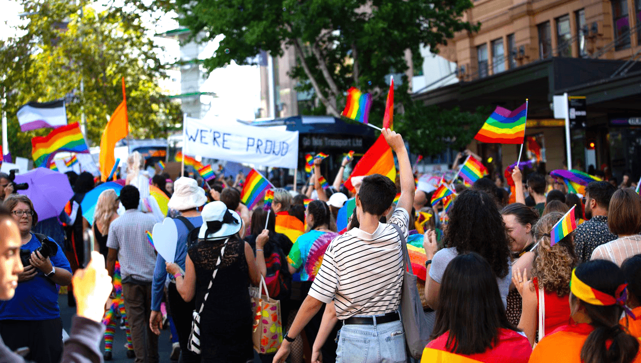 Marchers block the roads of Queen Street waving dozens of pride flags.