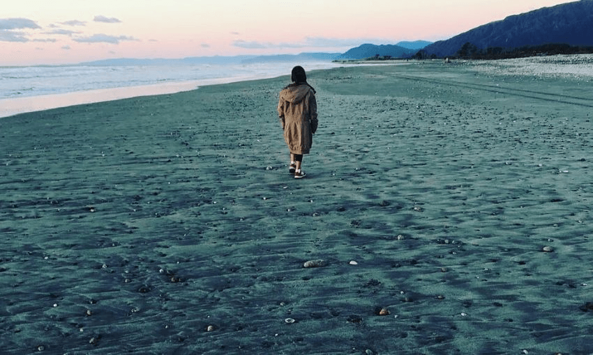 Becky’s daughter on Waimangaroa Beach, the Papahaua Ranges in the pink distance.  
