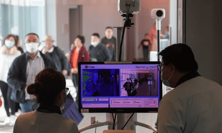 Health officers screen arriving passengers from China with thermal scanners at Changi International airport in Singapore (Photo by ROSLAN RAHMAN/AFP via Getty Images) 
