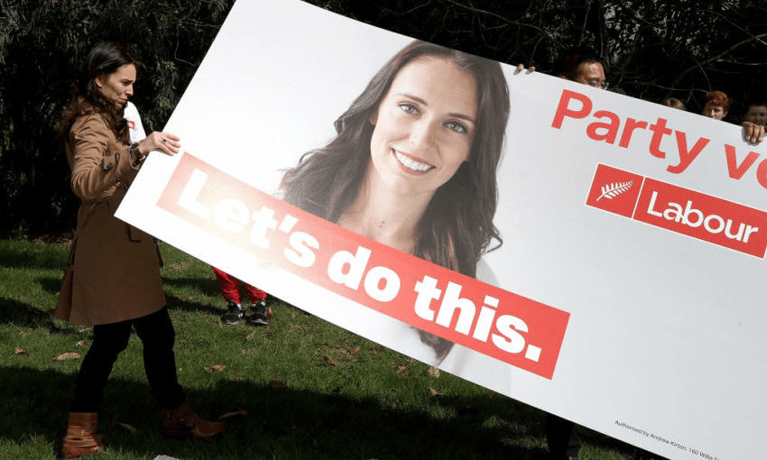 Jacinda Ardern with a hoarding featuring Jacinda Ardern in August 2017. Photo by Phil Walter/Getty Images 
