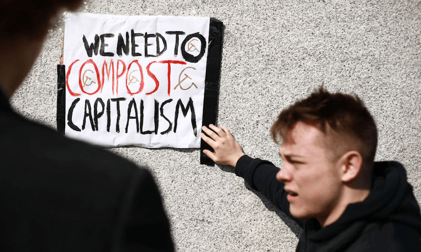 Members of the Marxist Student Federation fix an anti-capitalist sign to the base of the statue of Winston Churchill in Parliament Square ahead of the third climate ‘youth strike’ in London, England, on April 12, 2019. (Photo by David Cliff/NurPhoto) 
