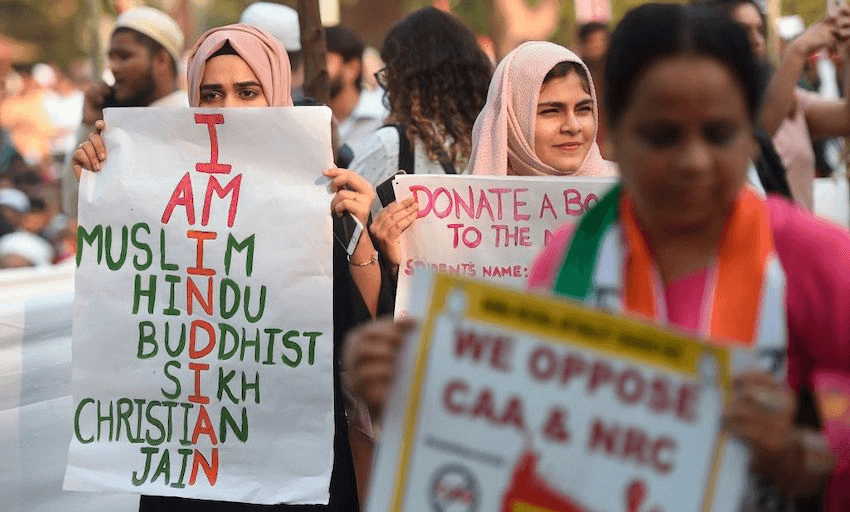 Protesters hold placards at a demonstration against India’s new citizenship law in Mumbai on December 19, 2019. (Photo by PUNIT PARANJPE/AFP via Getty Images) 
