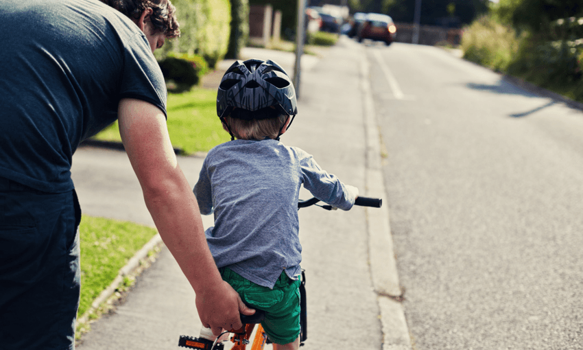 Little boy learning to ride a bicycle with his Father 
