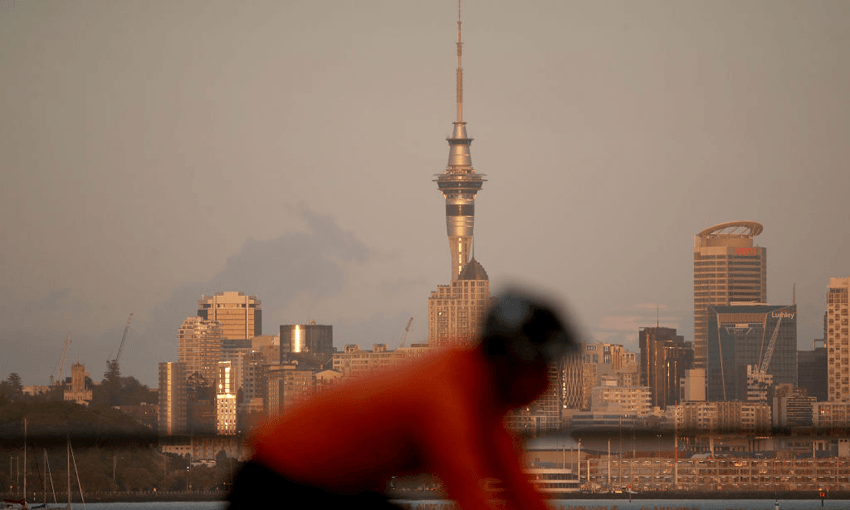 A cyclist with Auckland’s Sky Tower in the distance (Photo: Getty Images) 
