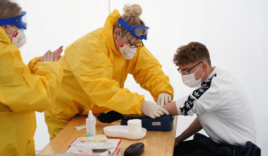 A blood sample is taken in a tent set up next to a doctor’s office in Berlin. (Photo by Sean Gallup/Getty Images) 

