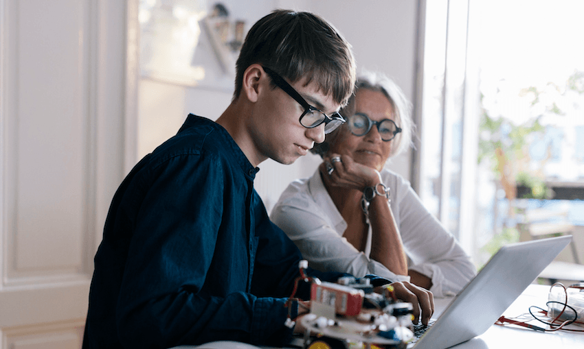 Mother helping son code a hobby electronic project. 
