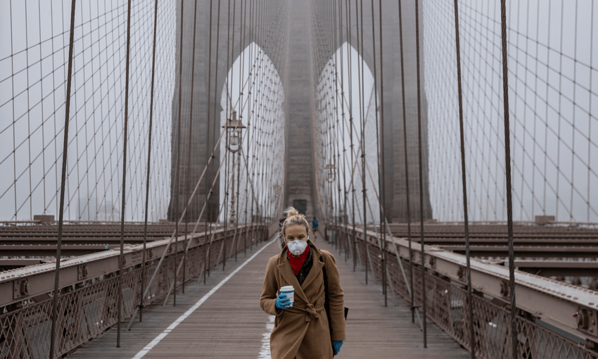 A woman wearing a mask walks the Brooklyn Bridge in the midst of the coronavirus outbreak in New York City (Photo by Victor J. Blue/Getty Images) 
