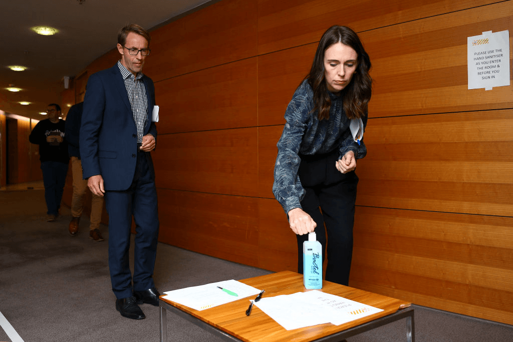 Jacinda Ardern and Ashley Bloomfield check in with the hand sanitiser on their way into a briefing (Photo: Hagen Hopkins/Getty Images)