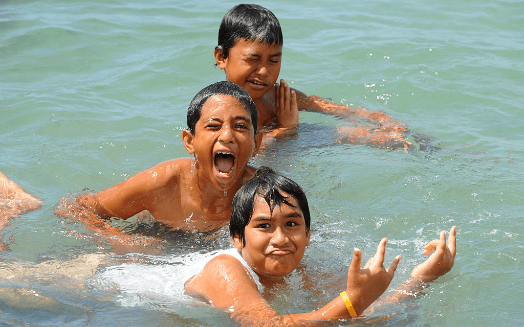 Boys playing in the surf in the Cook Islands (Photo: Getty Images) 
