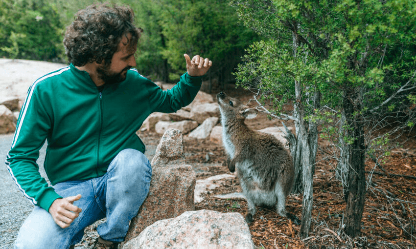 A Man who if you squint looks like he is from Flight of the Conchords catches up with a kangaroo in Tasmania. Photo: Getty 
