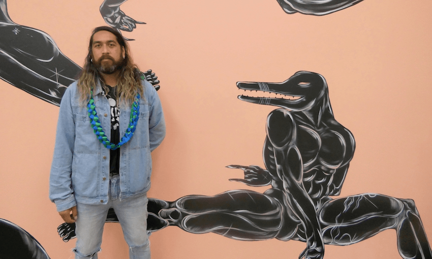 Neo-pop artist Ahsin Ahsin in front of his work at Moana Legacy, the opening exhibition of Tautai Gallery (Photo: Gareth Shute) 
