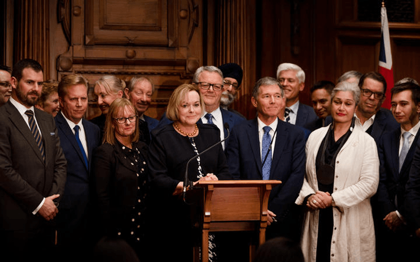 National Party leader Judith Collins addresses media with support from party members following the emergency caucus meeting on 14 July. (Photo: RNZ/Samuel Rillstone) 
