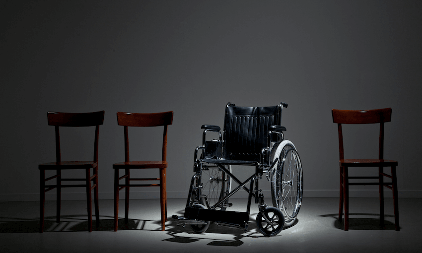 a wheelchair in the spotlight in a row of ordinary chairs
