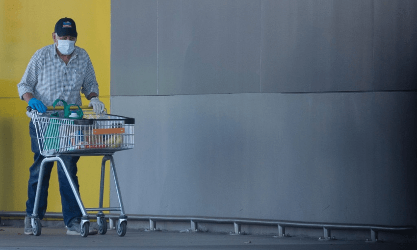 An elderly man wearing a face mask, pushes a shopping cart in Christchurch, New Zealand, on March 25, 2020. (Photo by Sanka Vidanagama/NurPhoto) 
