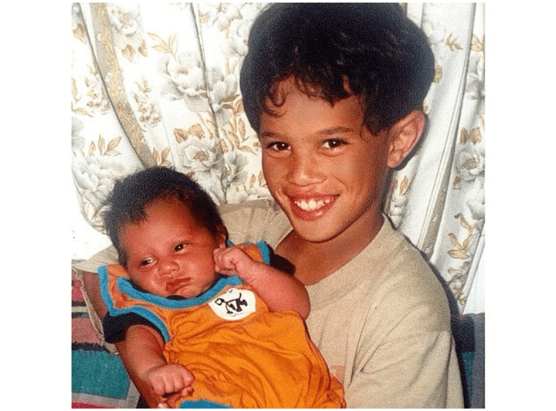 Eight-year-old Stan Walker beams as he holds his new baby brother, Noah
