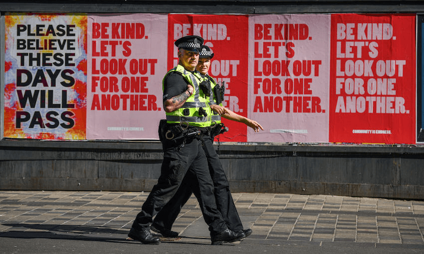 Two police officers walk past posters on Sauchiehall Street, Glasgow, during the coronavirus lockdown on May 6, 2020. (Photo: Jeff J Mitchell/Getty Images) 
