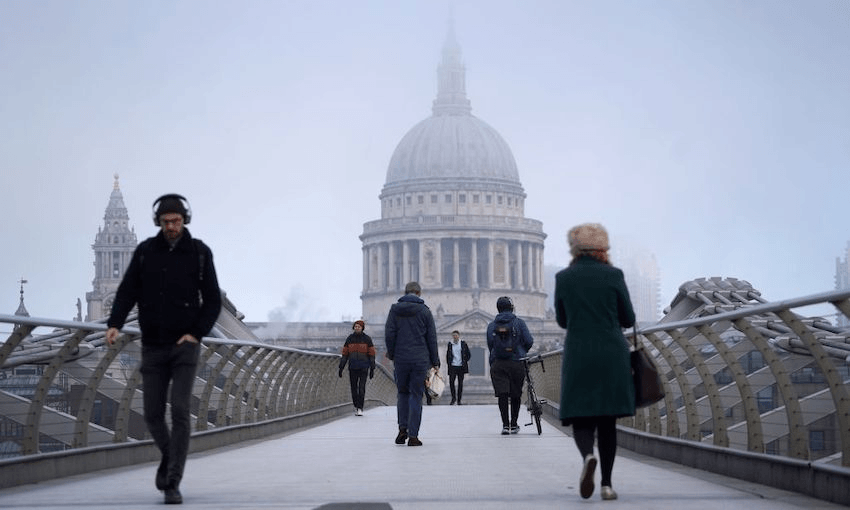 Pedestrians cross the near-deserted Millenium Bridge, with St Paul’s Cathedral in the background in the City of London, as England enters a second coronavirus lockdown on November 5, 2020 (Photo: NIKLAS HALLE’N/AFP via Getty Images) 
