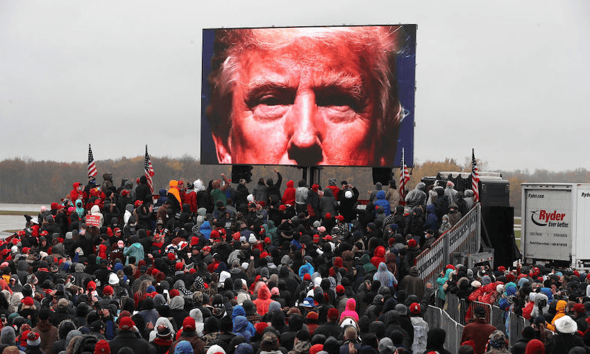Supporters watch a video of U.S. President Donald Trump while waiting in a cold rain for his arrival at a campaign rally on October 27, 2020 in Lansing, Michigan.  (Photo: Chip Somodevilla/Getty Images) 
