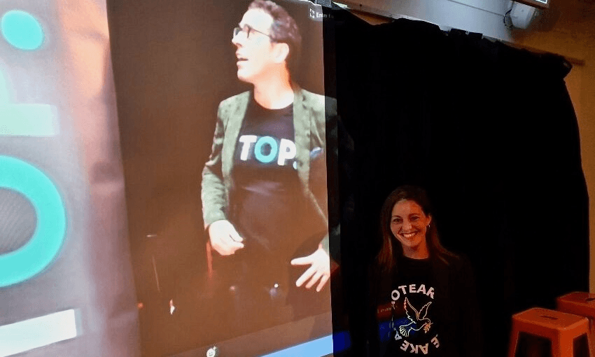 TOP INTERIM LEADER SHAI NAVOT STANDING IN FRONT OF THE LIVE STREAM OF GEOFF SIMMONS AT THE 2020 AGM (PHOTO: ALEX BRAAE)