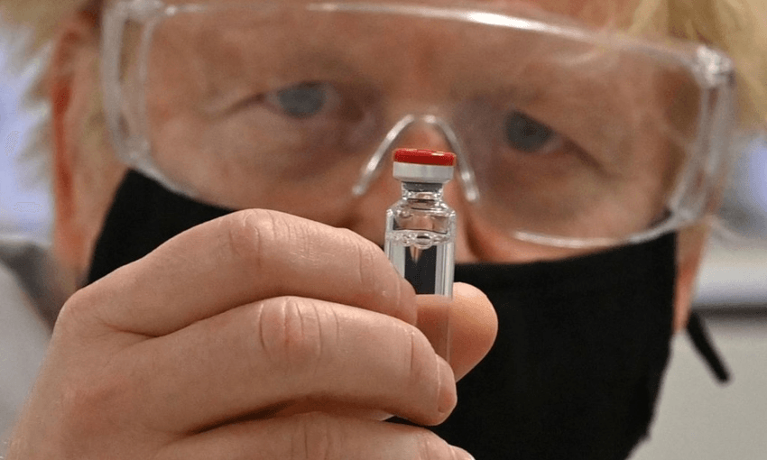 Boris Johnson poses with a vial of the AstraZeneca/Oxford University COVID-19 candidate vaccine. (Photo by Paul Ellis – WPA Pool/Getty Images) 
